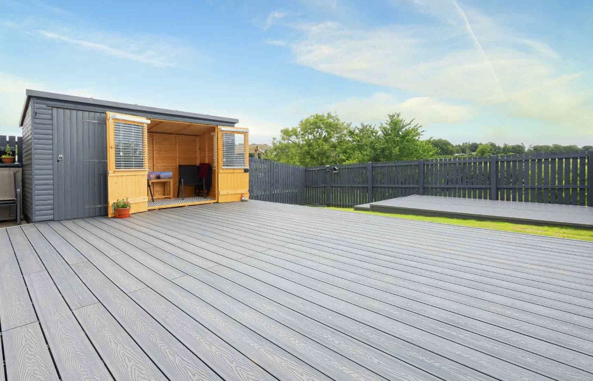 Modern gray composite deck installation with shed in Hawthorne backyard